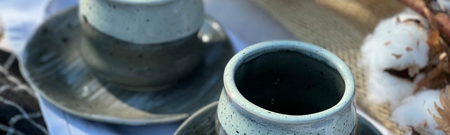 A set of handmade ceramic cups with saucers, perfect for morning coffee or tea.